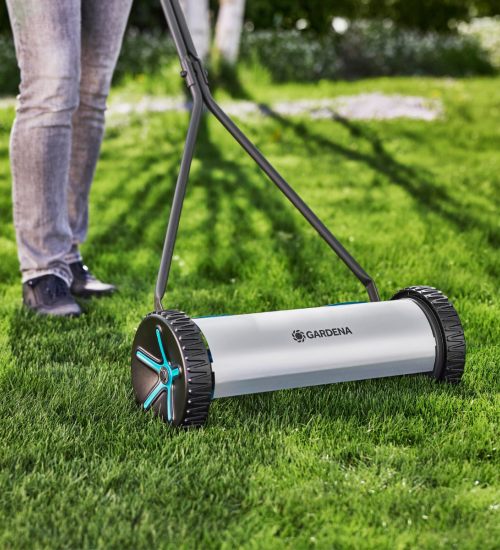 En person klipper sin gräsmatta med en Gardena Cylindergräsklippare Comfort 400.